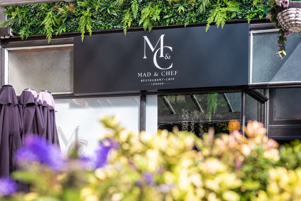 The Mad & Chef shopfront with the M&C sign, a living-wall of leaves and flowers in the foreground
