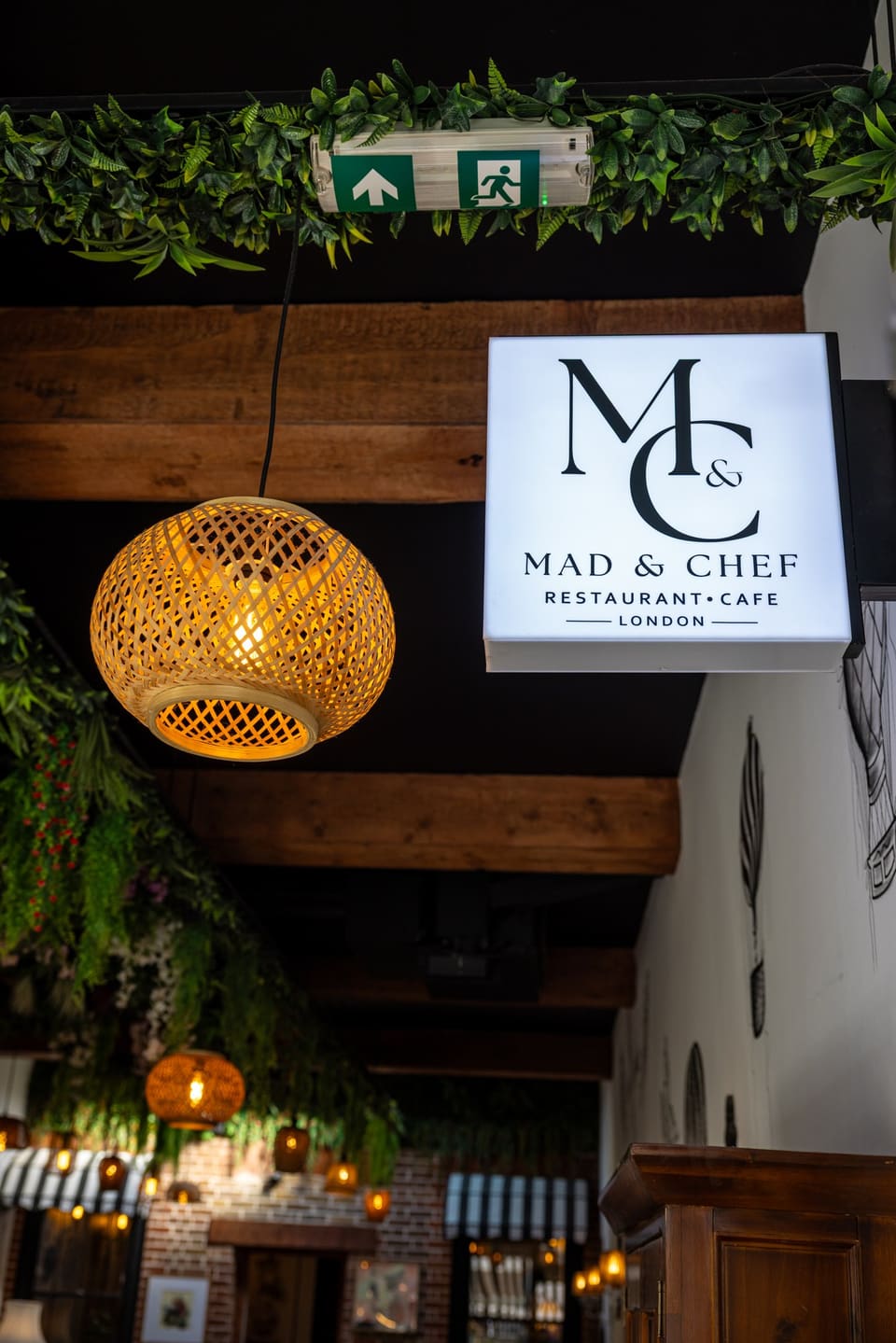 The illuminated M&C sign among the leaves